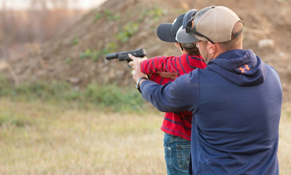 a man and a woman are aiming at a target
